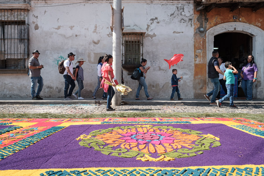 Passersby skirt completed alfombras that wait for the feet of an imminent procession.