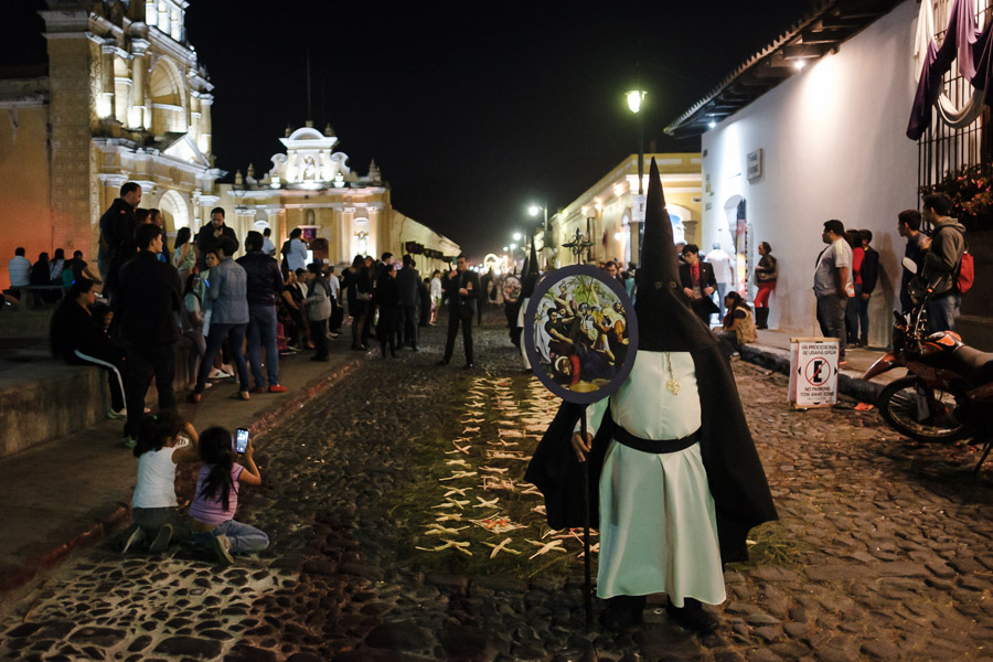 Children eagerly watch a midnight procession approach.