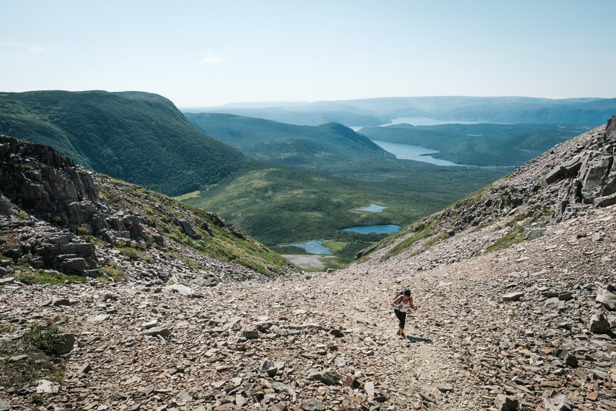 A hiker takes advantage of clear weather to access Gros Morne&rsquo;s peak through an approach up a rock strewn gully.