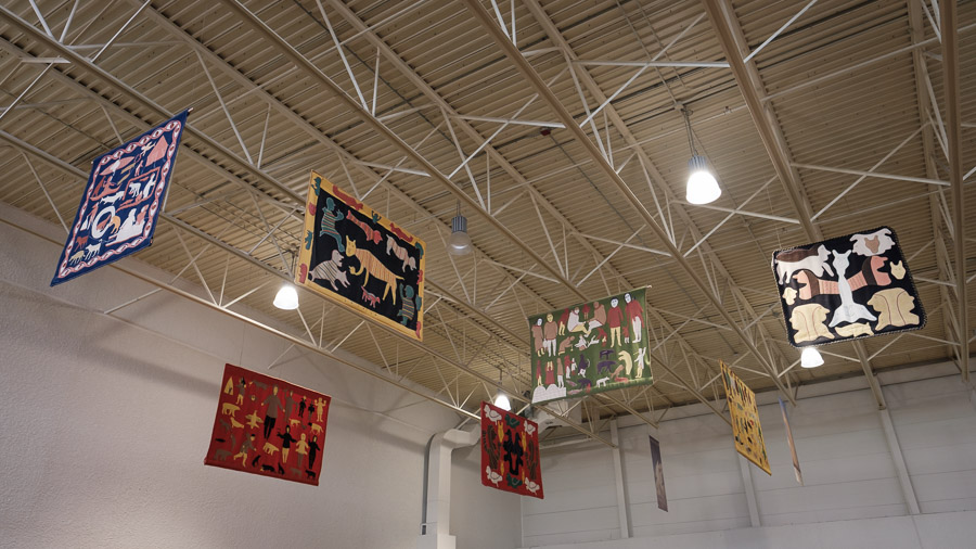 Traditional figures take form in storytelling tapestries.