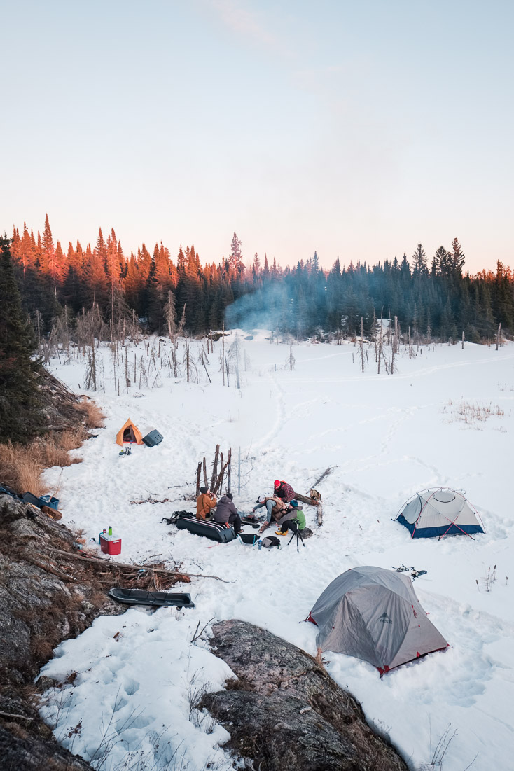 As the sun sets and the temperature drops, the fire becomes a beckoning hub when winter camping.Context: A moment from one of many close-to-home adventures in Manitoba. &ndash;link forthcoming&ndash;